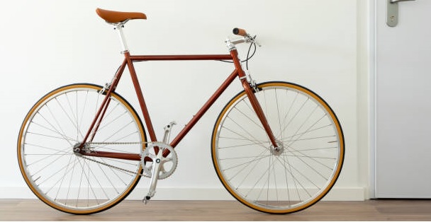 Photo of a bicycle leaning on a white wall